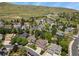 An aerial view showcases a beautiful neighborhood nestled against rolling hills and blue skies at 2146 S Ellis Ct, Lakewood, CO 80228