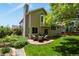 Exterior view of the home with a patio seating area, lush lawn, and landscaped garden beds at 2146 S Ellis Ct, Lakewood, CO 80228