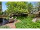 Lush backyard features a patio with seating, mature trees, a well-kept lawn and garden areas at 2146 S Ellis Ct, Lakewood, CO 80228