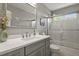 Modern bathroom features a gray vanity with white countertop and glass enclosed shower with a window at 2146 S Ellis Ct, Lakewood, CO 80228