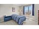 Bright bedroom with a blue striped bedspread, blue dresser, and a window with mountain views at 2146 S Ellis Ct, Lakewood, CO 80228