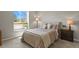 Comfortable bedroom with neutral tones, a plush bed, and ample natural light from a large window at 2146 S Ellis Ct, Lakewood, CO 80228