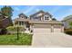 Inviting two-story home with a three-car garage, brick accents, and a beautifully landscaped front yard at 2146 S Ellis Ct, Lakewood, CO 80228