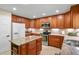 Well-appointed kitchen featuring wood cabinetry, granite countertops, stainless steel appliances, and a center island at 2146 S Ellis Ct, Lakewood, CO 80228