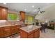 Open kitchen with wood cabinetry, granite island, stainless appliances, connected to dining area, filled with light at 2146 S Ellis Ct, Lakewood, CO 80228