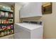 Functional laundry room with a stacked washer and dryer, shelving, and ample storage space at 2146 S Ellis Ct, Lakewood, CO 80228