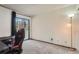 Bright bedroom featuring sliding glass doors to a balcony, neutral carpet, and ample natural light at 8225 Fairmount Dr # 104, Denver, CO 80247
