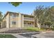 Two-story apartment building with balconies, landscaping, and dedicated parking spots at 8225 Fairmount Dr # 104, Denver, CO 80247