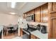 Kitchen with stainless steel appliances and wooden cabinets, leading to a dining area at 8225 Fairmount Dr # 104, Denver, CO 80247
