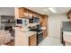 Open-concept kitchen with breakfast bar, stainless appliances, and view of the living area at 8225 Fairmount Dr # 104, Denver, CO 80247