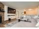 Open-concept living room with a modern sectional, a fireplace, and an open view to the kitchen at 8225 Fairmount Dr # 104, Denver, CO 80247