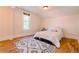 Bright bedroom with a hardwood floor, decorative rug, and a white bed with a window providing natural light at 131 Fox St, Denver, CO 80223