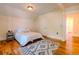 Cozy bedroom featuring a plush rug, hardwood floors, a comfortable bed, and doorway to another room at 131 Fox St, Denver, CO 80223