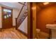 A beautiful entryway with wood floors, dark wood staircase and decorative orange wallpaper at 131 Fox St, Denver, CO 80223