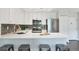 Modern kitchen with white cabinets, stainless steel appliances, and a breakfast bar at 3470 S Poplar St # 404, Denver, CO 80224