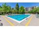 A clear blue swimming pool with plenty of lounge chairs and green trees in the background on a sunny day at 3470 S Poplar St # 404, Denver, CO 80224