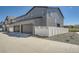 Two-story gray siding home features an attached two-car garage, white picket fence, and concrete driveway at 1290 S Algonquian St, Aurora, CO 80018