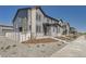 New townhome showcasing a modern exterior with gray siding, painted brick accents, and landscaped front yard on a sunny day at 1290 S Algonquian St, Aurora, CO 80018