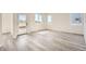 Bright, airy living room featuring stylish gray wood flooring, three large windows and lots of natural light at 1290 S Algonquian St, Aurora, CO 80018