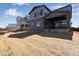 Backyard view of a gray home with a covered patio and a spacious yard ready for landscaping at 9973 Worchester St, Commerce City, CO 80022