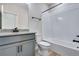 Bathroom featuring a grey vanity with granite countertop, toilet, and a white tiled shower and tub at 9973 Worchester St, Commerce City, CO 80022