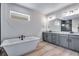 Bright bathroom featuring a soaking tub, dual vanities, and modern fixtures at 9973 Worchester St, Commerce City, CO 80022