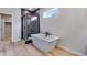 Modern bathroom with a soaking tub, shower, and wood-look flooring at 9973 Worchester St, Commerce City, CO 80022