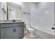 Modern bathroom featuring gray vanity, white tiled shower and tub at 9973 Worchester St, Commerce City, CO 80022