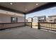 Covered patio with concrete flooring, black railing, and recessed lighting, perfect for outdoor entertaining at 9973 Worchester St, Commerce City, CO 80022