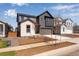 Attractive two-story gray home featuring a two-car garage, and a beautifully landscaped front yard at 9973 Worchester St, Commerce City, CO 80022