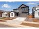 Attractive two-story gray home featuring a two-car garage, and a well maintained front yard at 9973 Worchester St, Commerce City, CO 80022