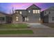 Two-story gray home featuring a two-car garage, manicured lawn, and inviting front entrance at 9973 Worchester St, Commerce City, CO 80022