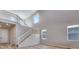 Bright living room features soaring ceilings and access to a staircase that leads to the second story at 9973 Worchester St, Commerce City, CO 80022