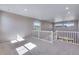 Open loft area with neutral walls, recessed lighting, carpet flooring, and a staircase with white railing at 9973 Worchester St, Commerce City, CO 80022