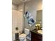 Bathroom with decorative artwork and dark vanity, white tile in bath/shower combo at 17630 W 94Th Dr, Arvada, CO 80007