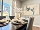 Dining room table setting, artwork, and sliding door to a sunny backyard at 17630 W 94Th Dr, Arvada, CO 80007