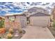 Charming two-story home featuring stone accents, a two-car garage, and a beautifully landscaped front yard at 17630 W 94Th Dr, Arvada, CO 80007