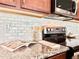 Kitchen detail with marble backsplash, stainless steel appliances, and granite countertops at 17630 W 94Th Dr, Arvada, CO 80007