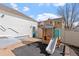 A backyard with a play structure, and a glimpse of neighboring houses under a sunny sky at 6324 Winona St, Arvada, CO 80003