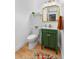 Charming powder room showcasing a green vanity, gold-trimmed mirror, and modern fixtures at 6324 Winona St, Arvada, CO 80003
