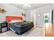 Bedroom with an orange headboard featuring a doorway to the bathroom at 6324 Winona St, Arvada, CO 80003