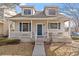Charming two-story home with a welcoming front porch, complemented by a well-maintained yard and blue shutters at 6324 Winona St, Arvada, CO 80003