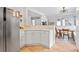 Bright kitchen showcases an open floor plan, stainless steel fridge and light wood floors at 6324 Winona St, Arvada, CO 80003