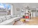Bright living room featuring a comfortable gray sectional sofa, hardwood floors, and an abundance of natural light at 6324 Winona St, Arvada, CO 80003