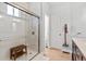 Modern bathroom with glass walk-in shower and wood bench at 6324 Winona St, Arvada, CO 80003