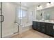 Modern bathroom featuring a tub and separate shower, with a double vanity at 6099 N Netherland Ct, Aurora, CO 80019