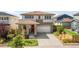 Landscaped two-story home boasts a welcoming entrance and attached two car garage at 6099 N Netherland Ct, Aurora, CO 80019