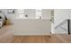 Upper-level hallway featuring hardwood floors and a half-wall with views to the downstairs living area at 6099 N Netherland Ct, Aurora, CO 80019