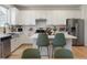 Bright kitchen boasts white cabinets, stainless appliances, and a functional center island with stylish seating at 6099 N Netherland Ct, Aurora, CO 80019