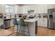 Modern kitchen featuring white cabinets, stainless steel appliances, and a center island with seating and stylish accents at 6099 N Netherland Ct, Aurora, CO 80019